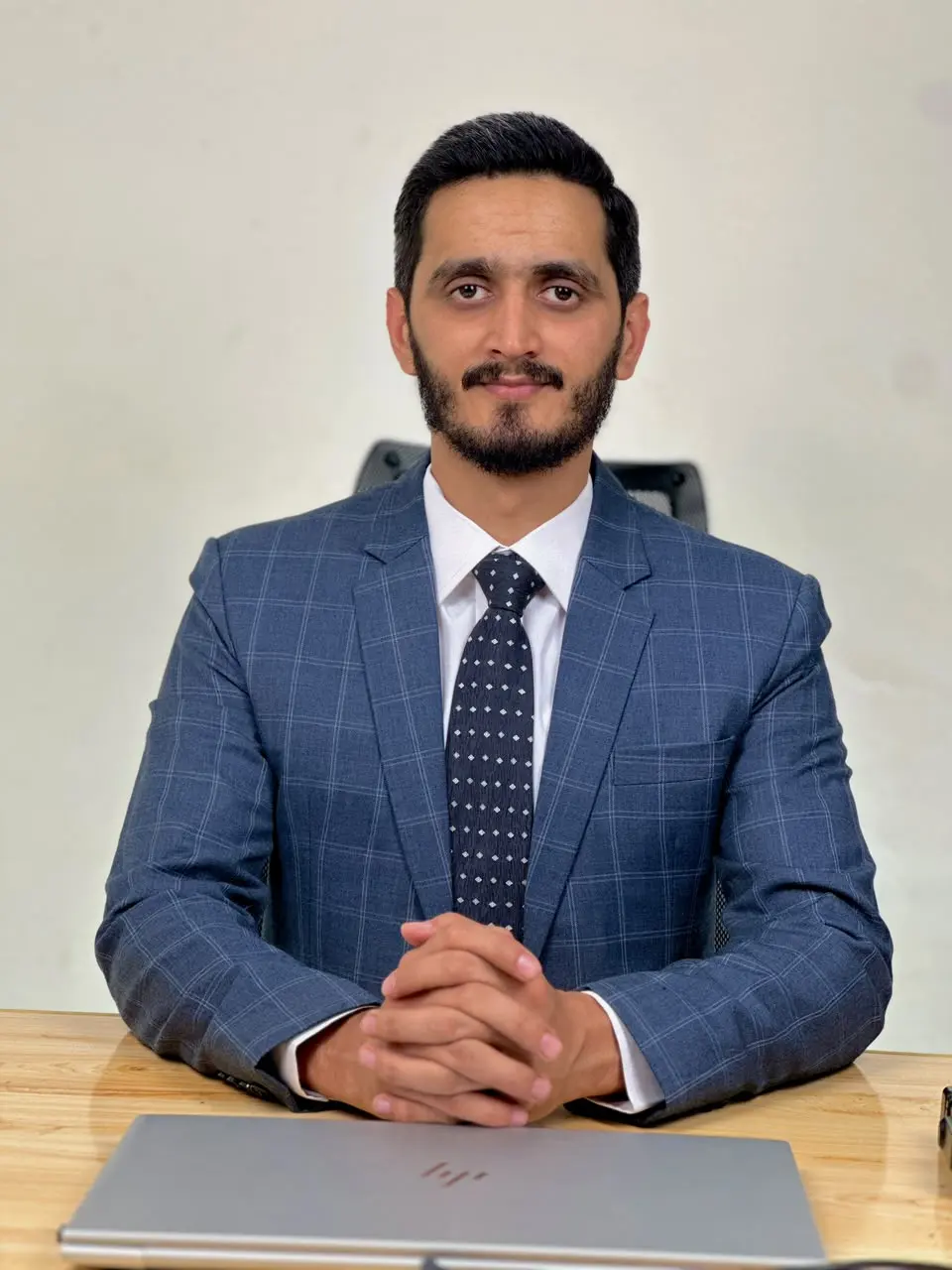 Hasnat Azam, founder of Rewokers Advertising, seated at a desk in a blue suit